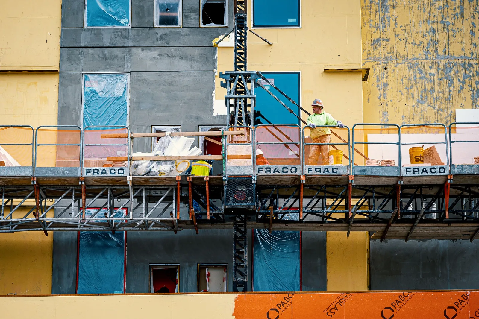 Vakman op een hoogwerker tijdens een gevelrenovatie